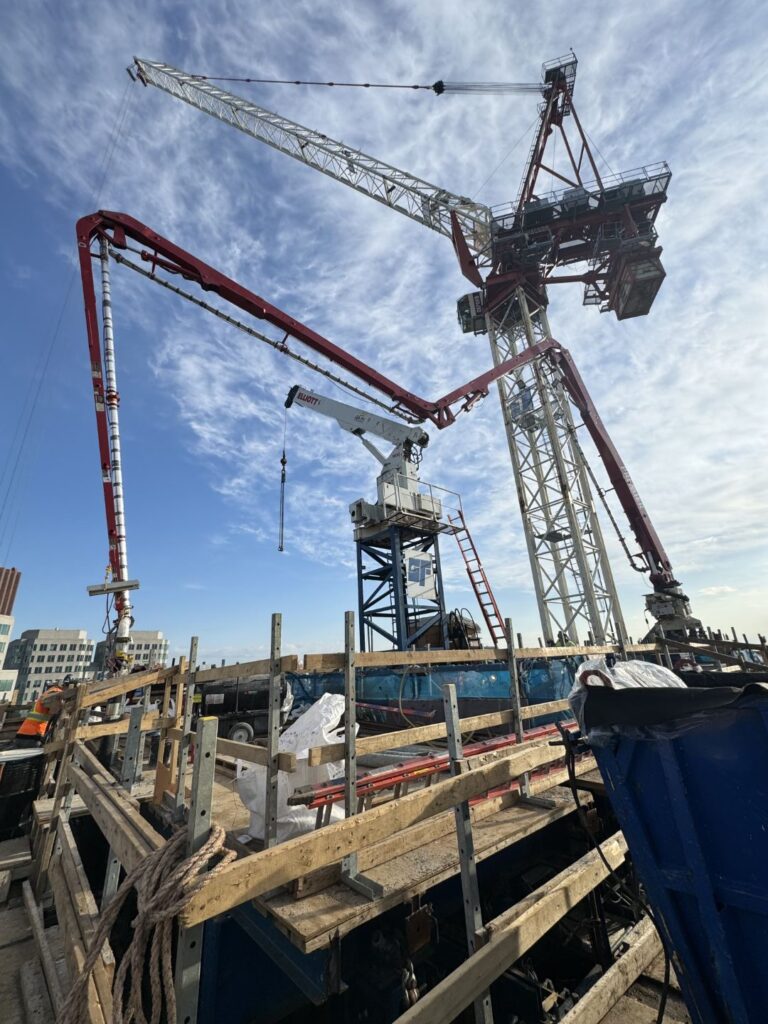 Placing boom pump in operation at construction site - Premier Concrete Pumping Ontario